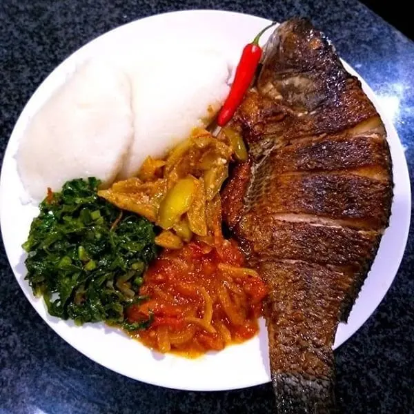 Ugali with fried samaki, sukuma wiki and tomato sauce